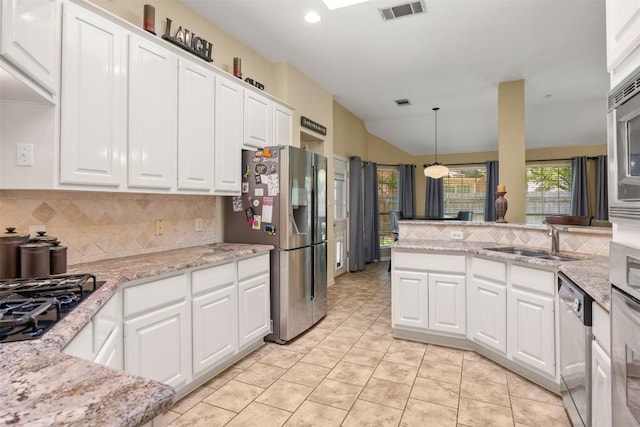 2025 Saint Andrews Dr, Round Rock, TX 78664 - kitchen featuring appliances with stainless steel finishes, decorative backsplash, a sink, white cabinets, and vaulted ceiling