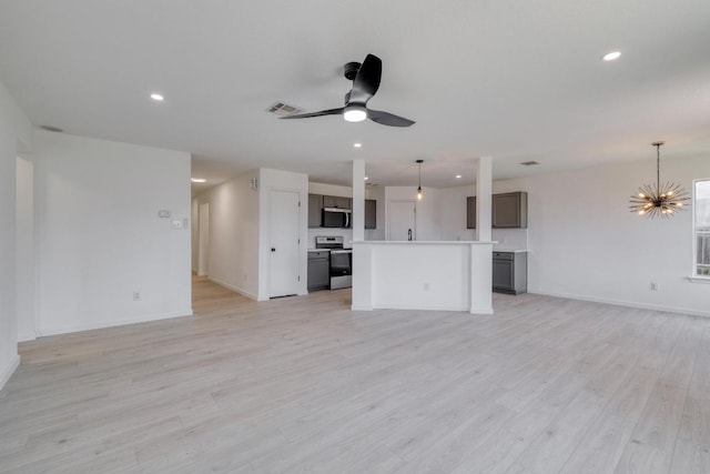 303 Flinn St, Hutto, TX 78634 - unfurnished living room with ceiling fan, recessed lighting, light wood finished floors, baseboards, and a chandelier