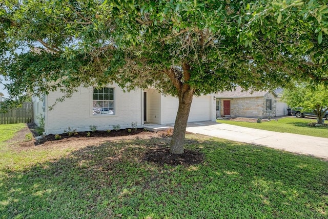 303 Flinn St, Hutto, TX 78634 - view of property hidden behind natural elements with driveway, a garage, and brick siding