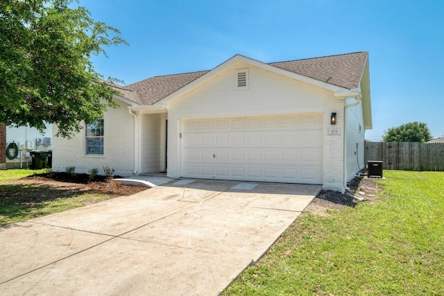 303 Flinn St, Hutto, TX 78634 - view of front of property with brick siding, an attached garage, concrete driveway, and roof with shingles