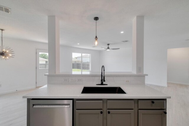 303 Flinn St, Hutto, TX 78634 - kitchen featuring dishwasher, a sink, open floor plan, gray cabinets, and light wood finished floors