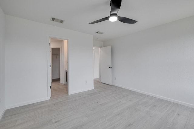 303 Flinn St, Hutto, TX 78634 - unfurnished bedroom with light wood finished floors, baseboards, a spacious closet, and ceiling fan