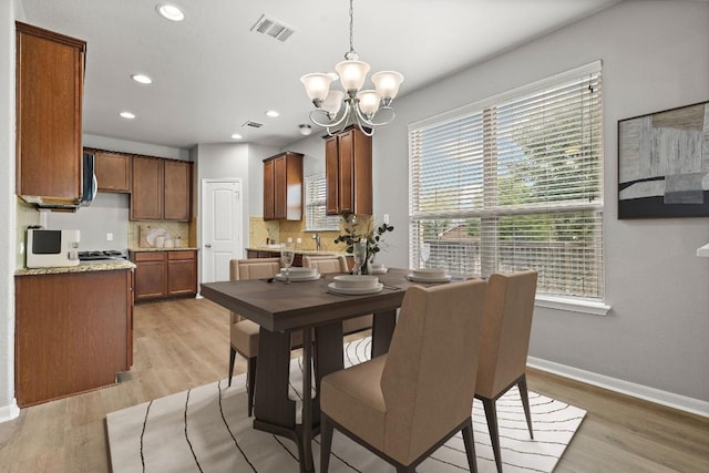 dining area with a chandelier, baseboards, recessed lighting, and light wood-style flooring
