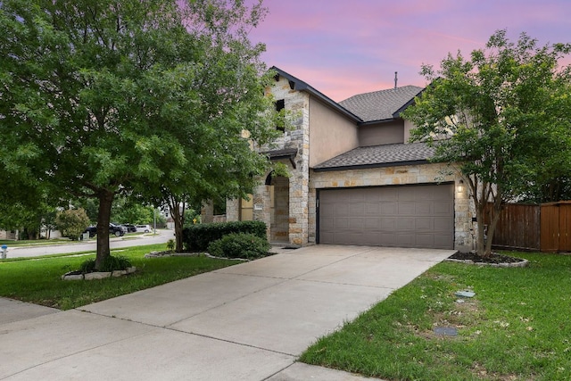 view of front of home featuring stone siding, concrete driveway, a garage, roof with shingles, and stucco siding