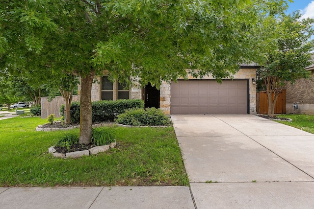 view of property hidden behind natural elements featuring driveway, stone siding, and an attached garage
