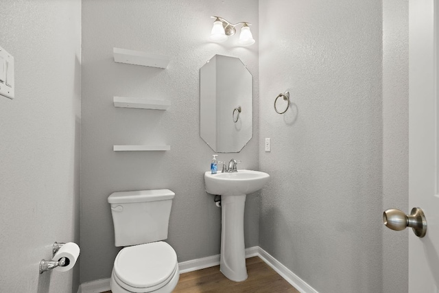 bathroom featuring wood finished floors, toilet, and baseboards