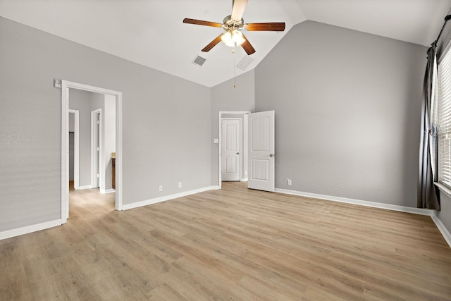 unfurnished bedroom featuring attic access, light wood-type flooring, high vaulted ceiling, baseboards, and ceiling fan