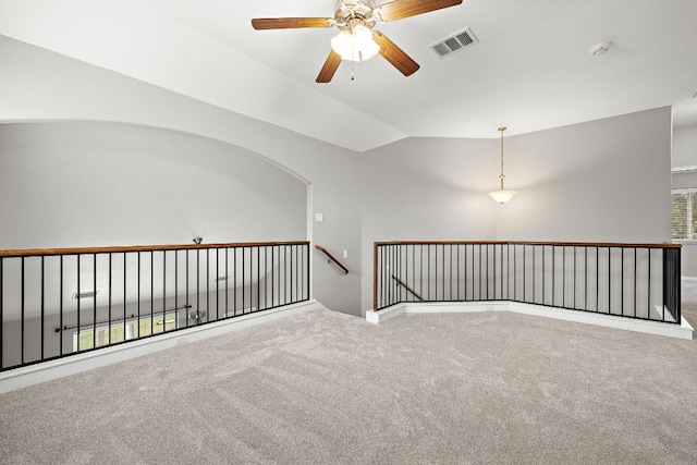 carpeted empty room featuring a ceiling fan and lofted ceiling