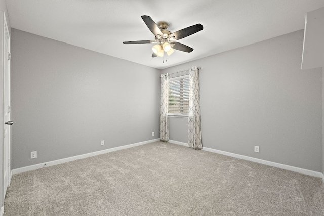 carpeted empty room with ceiling fan and baseboards