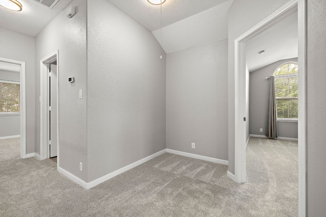 hall featuring vaulted ceiling, carpet, and baseboards