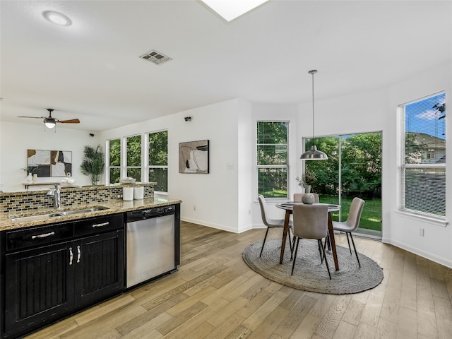 kitchen featuring dishwasher, a sink, dark cabinets, and baseboards