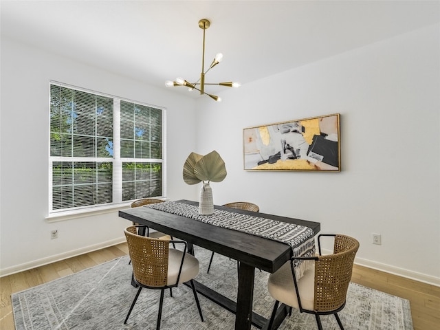 dining area with a chandelier, baseboards, and wood finished floors