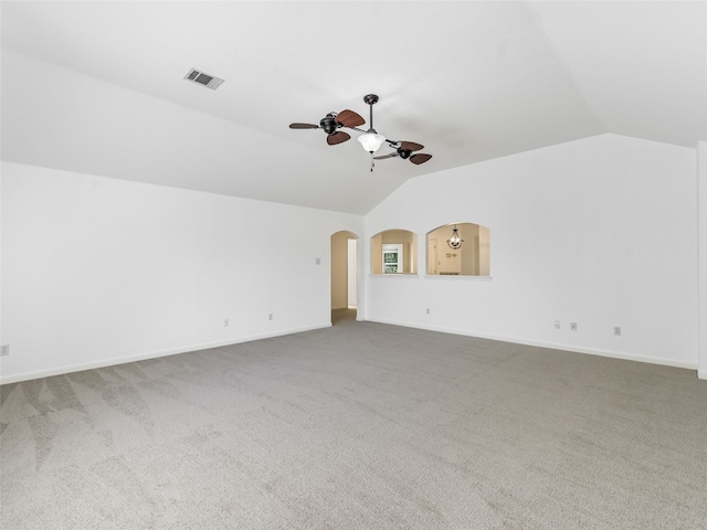 unfurnished living room featuring lofted ceiling, a ceiling fan, carpet, arched walkways, and baseboards