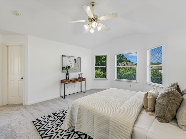 bedroom featuring light carpet, baseboards, vaulted ceiling, and a ceiling fan