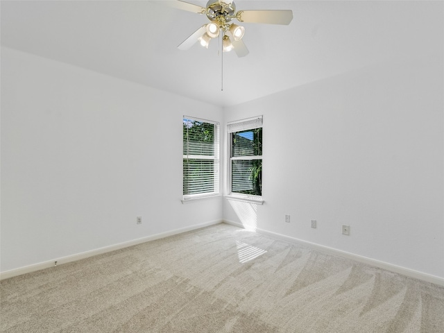 unfurnished room with light colored carpet, baseboards, and a ceiling fan