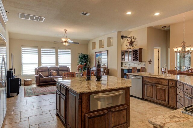 kitchen featuring a warming drawer, stainless steel dishwasher, ceiling fan, a sink, and a chandelier