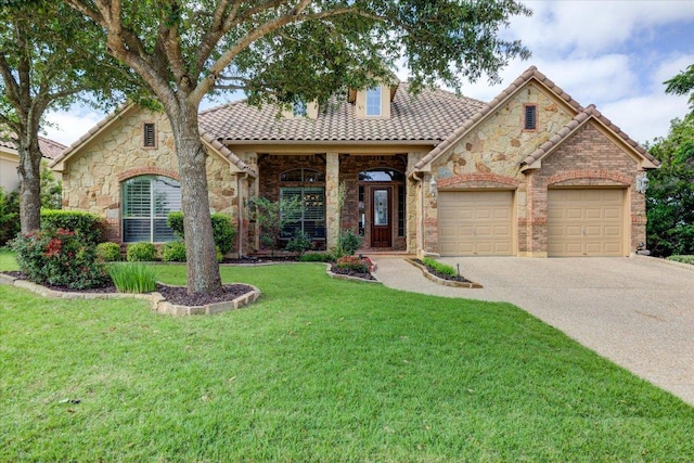 view of front of home featuring driveway, stone siding, a front yard, an attached garage, and a tiled roof