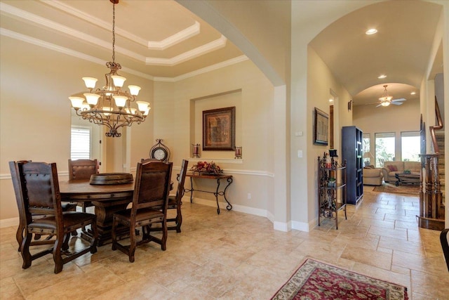 dining area with arched walkways, baseboards, a chandelier, ceiling fan, and a high ceiling