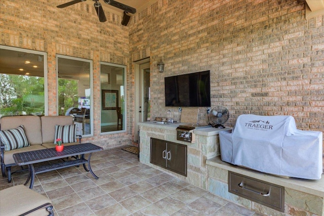 view of patio / terrace with exterior kitchen, ceiling fan, a sink, and outdoor lounge area