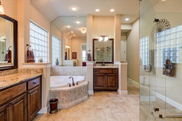 bathroom with a shower stall, plenty of natural light, a bath, two vanities, and recessed lighting