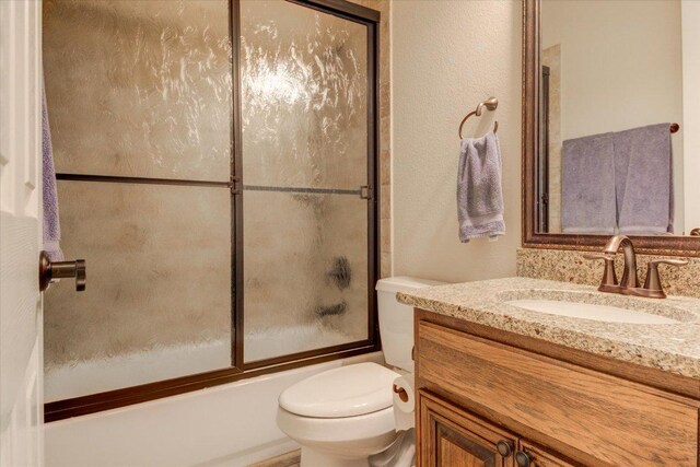 3920 Vail Dv, Bee Cave, TX 78738 - bathroom featuring vanity, toilet, and shower / bath combination with glass door