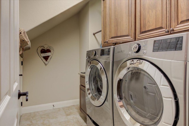 washroom featuring separate washer and dryer, cabinet space, and baseboards