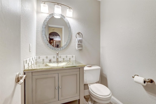 9840 N Live Oak Rd, Salado, TX 76571 - bathroom featuring toilet, vanity, a textured wall, and baseboards