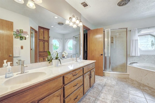 9840 N Live Oak Rd, Salado, TX 76571 - full bathroom featuring a shower stall, a textured ceiling, a bath, double vanity, and tile patterned floors