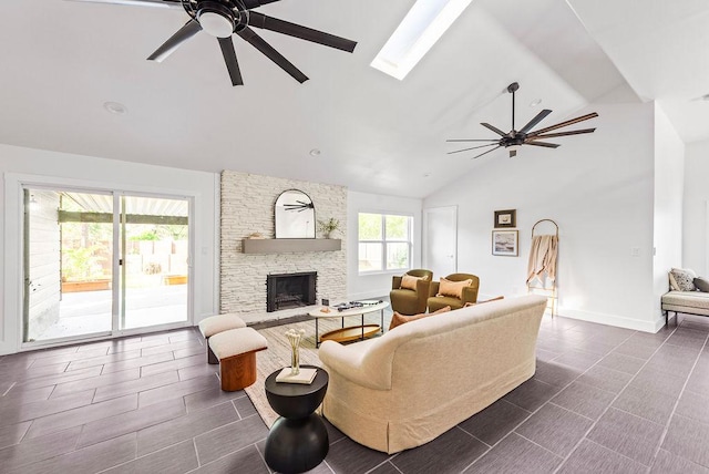 4535 Pack Saddle Pass, Austin, TX 78745 - living room with ceiling fan, a fireplace, a skylight, high vaulted ceiling, and dark tile patterned floors