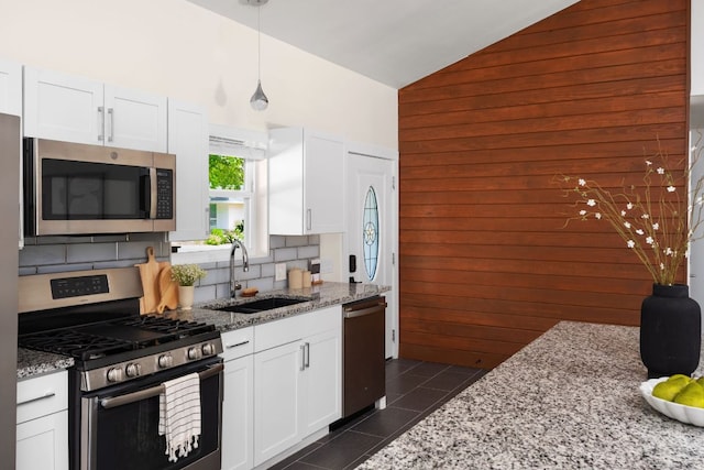 4535 Pack Saddle Pass, Austin, TX 78745 - kitchen featuring stainless steel appliances, high vaulted ceiling, a sink, wooden walls, and white cabinetry