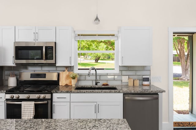 4535 Pack Saddle Pass, Austin, TX 78745 - kitchen featuring stainless steel appliances, a sink, backsplash, white cabinets, and light stone countertops