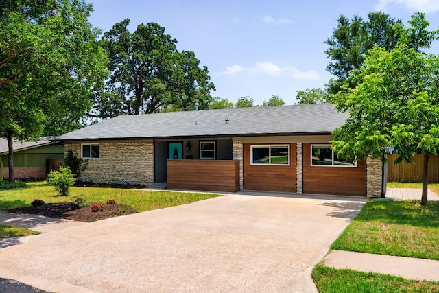 4535 Pack Saddle Pass, Austin, TX 78745 - view of front of house featuring stone siding, concrete driveway, and a front lawn
