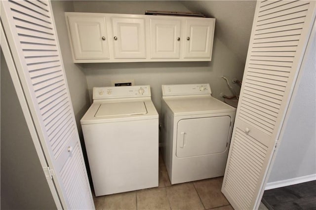 clothes washing area with cabinet space, washer and clothes dryer, and light tile patterned flooring