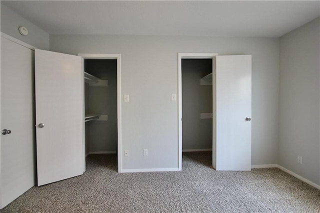unfurnished bedroom featuring a spacious closet, a closet, and carpet