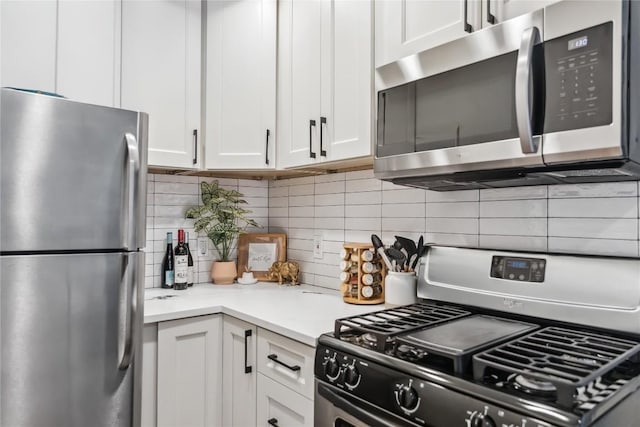 kitchen with stainless steel appliances, decorative backsplash, white cabinetry, and light countertops