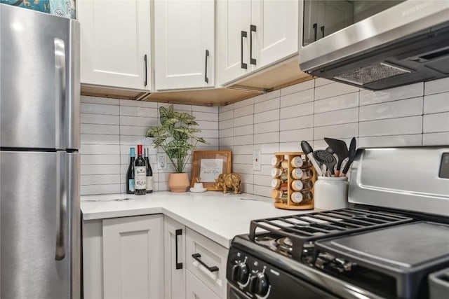kitchen featuring appliances with stainless steel finishes, tasteful backsplash, white cabinets, and extractor fan