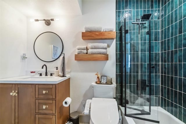 full bathroom with a tile shower, vanity, and toilet