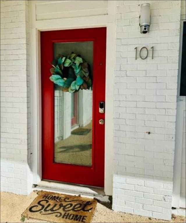 view of exterior entry featuring brick siding