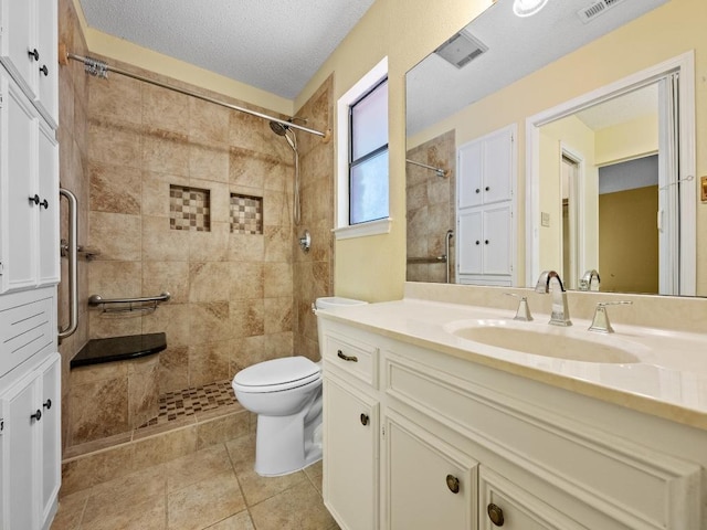 3606 Spotted Horse Trl, Austin, TX 78739 - bathroom featuring vanity, tiled shower, a textured ceiling, and tile patterned floors