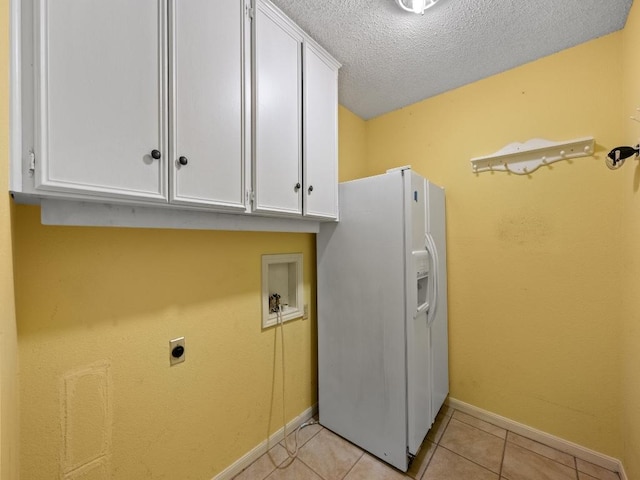 3606 Spotted Horse Trl, Austin, TX 78739 - washroom with hookup for an electric dryer, cabinet space, light tile patterned floors, a textured ceiling, and hookup for a washing machine