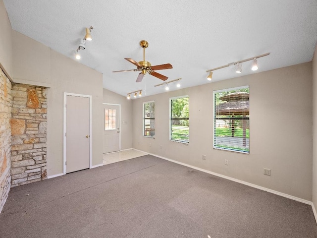 3606 Spotted Horse Trl, Austin, TX 78739 - carpeted spare room with rail lighting, healthy amount of natural light, a ceiling fan, a textured ceiling, and vaulted ceiling