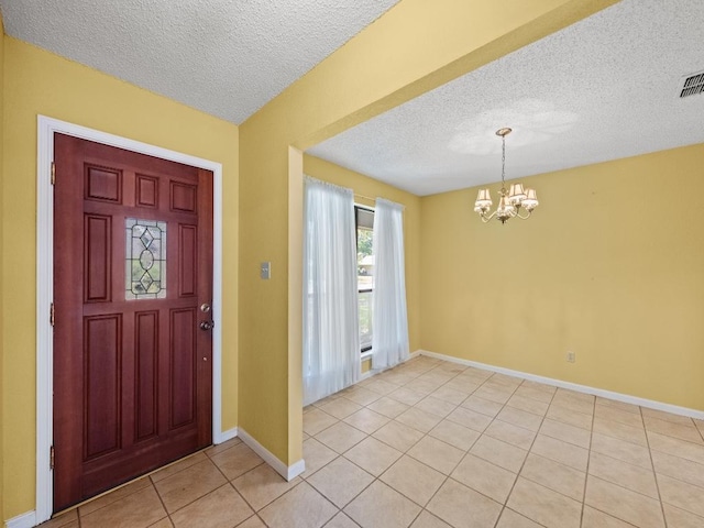 3606 Spotted Horse Trl, Austin, TX 78739 - entrance foyer featuring a chandelier, a textured ceiling, and light tile patterned floors