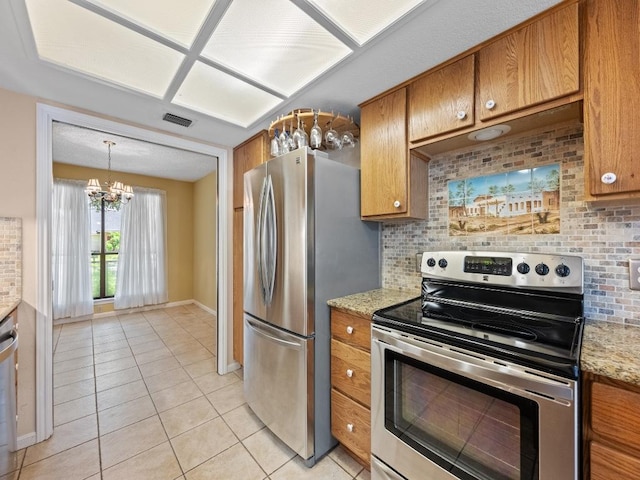3606 Spotted Horse Trl, Austin, TX 78739 - kitchen with appliances with stainless steel finishes, brown cabinets, light tile patterned floors, and backsplash