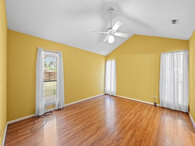 3606 Spotted Horse Trl, Austin, TX 78739 - spare room with a ceiling fan, vaulted ceiling, wood finished floors, and a textured ceiling