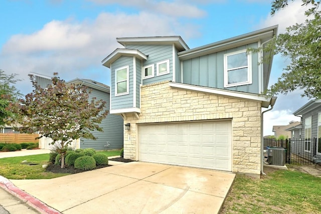 7308 Oberon St, Austin, TX 78741 - view of front of home featuring board and batten siding, stone siding, a garage, and concrete driveway