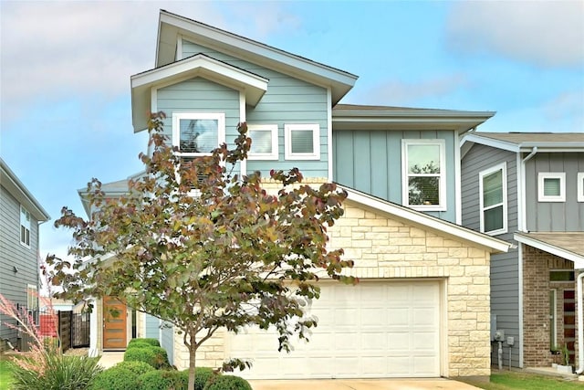 7308 Oberon St, Austin, TX 78741 - view of front of property with board and batten siding, stone siding, and concrete driveway