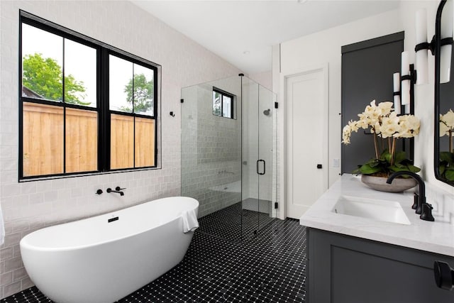 1703 Madison Ave, Austin, TX 78757 - full bath featuring a shower stall, a soaking tub, tile walls, tile patterned floors, and vanity