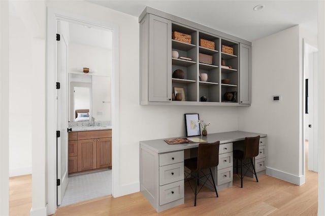 1703 Madison Ave, Austin, TX 78757 - office with light wood-style floors, built in desk, baseboards, and a sink
