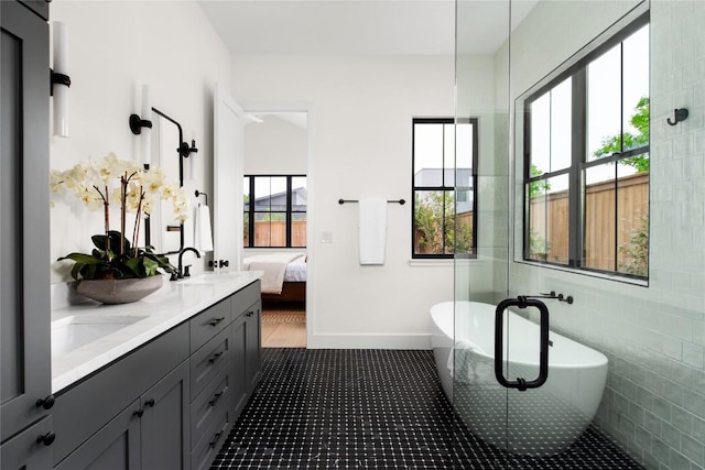 1703 Madison Ave, Austin, TX 78757 - bathroom featuring a freestanding tub, ensuite bath, double vanity, and baseboards