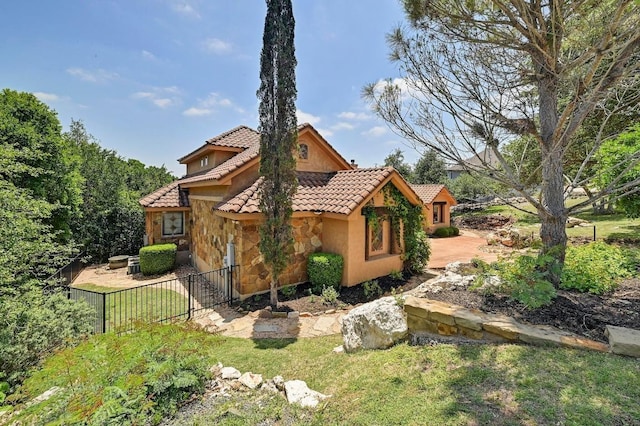 2600 Grapevine Springs Cv, Georgetown, TX 78628 - back of house with a tile roof, stone siding, and stucco siding